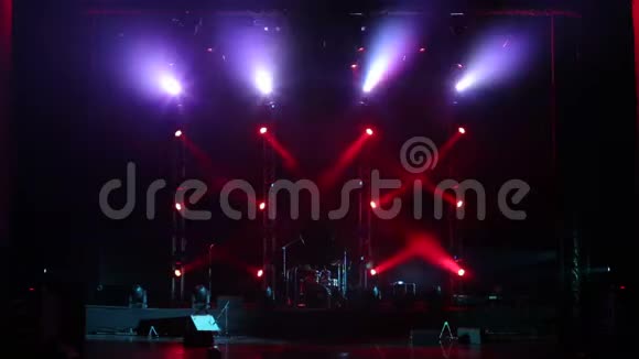 在舞台上的一场音乐会中交替闪烁红色和紫色的聚光灯视频的预览图