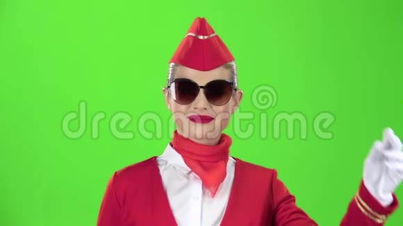 戴着太阳镜的女乘务员穿着红色西装闪烁着轻微的调情绿色屏幕慢动作关门视频的预览图