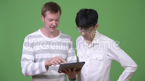 两位年轻的多民族商人展示数码平板电脑并竖起大拇指视频的预览图