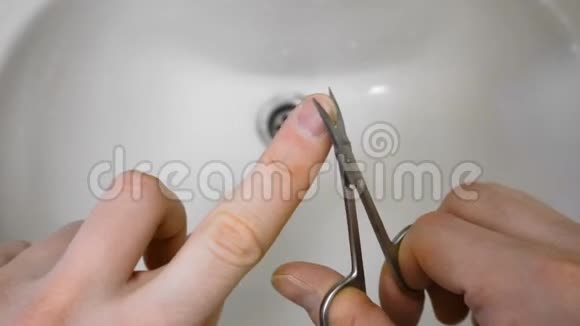 早晨人们用剪刀在洗手盆或手盆上剪指甲视频的预览图