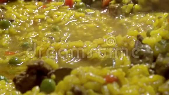 厨师用胡椒和鸡肝在煎锅里煮黄米饭视频的预览图