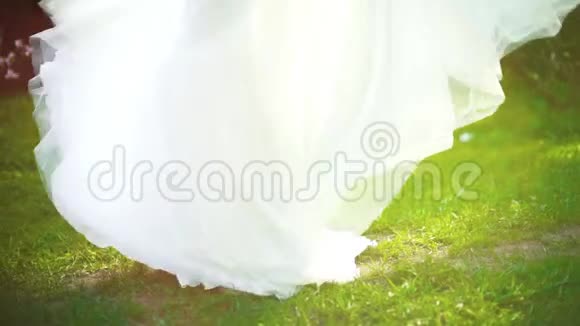 穿着婚纱的女人在绿色花园里慢镜头转过来视频的预览图