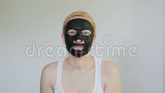 一个脸上戴着黑布化妆面具的女人给镜头送上一个空气吻视频的预览图