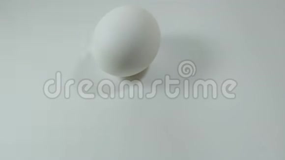鸡蛋在白色桌子上旋转和滚动复活节彩蛋视频的预览图