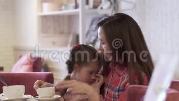 侧景一位年轻的母亲抱着她美丽的小女儿视频的预览图