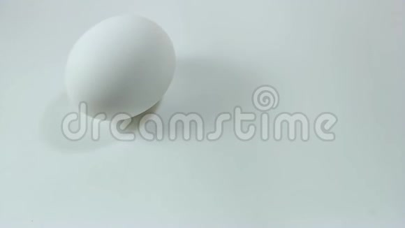 鸡蛋在白色桌子上旋转和滚动复活节彩蛋视频的预览图