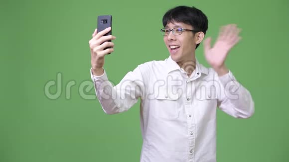 快乐的年轻亚洲商人微笑着打视频电话视频的预览图