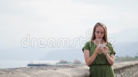 海普斯特女孩带着背包拿着智能手机小玩意在沙滩海岸线使用女性手提手机的旅行者视频的预览图