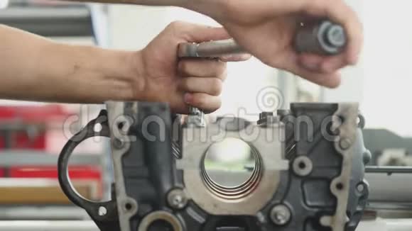 Chernivtsi这个人在车库里拧动汽车发动机的螺栓视频的预览图