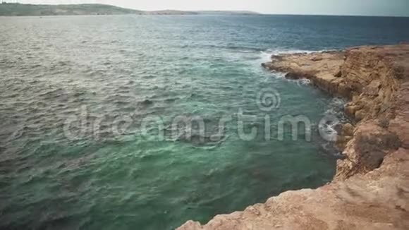 在阳光明媚的天气里观看大海和岩石悬崖碧海柔波视频的预览图