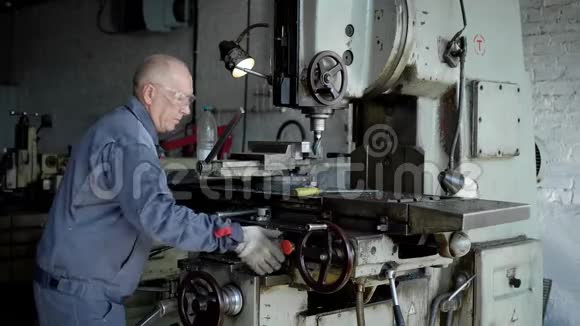 生产中的老人机器上的工人钻金属零件视频的预览图