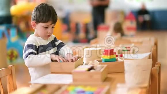 可爱的小男孩在幼儿园玩建筑玩具视频的预览图
