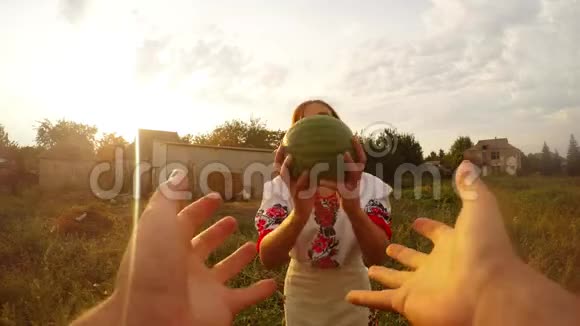 一个穿着乌克兰民俗服装的女孩在镜头前给一个人一个西瓜一个人看视频的预览图