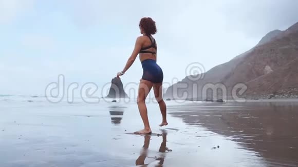 一位妇女在大西洋沿岸表演坐式节目健康生活方式的概念参加体育运动视频的预览图