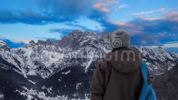 一个男孩观察白天到黑夜的流逝月亮在山上升起视频的预览图
