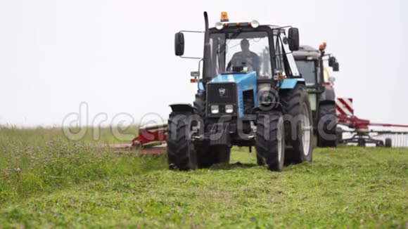 农用拖拉机在农田草缘上的生产线视频的预览图