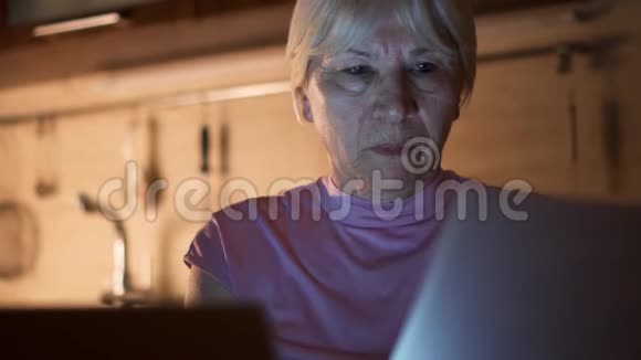 高级女性自由职业者晚上从家庭办公室使用笔记本电脑工作过度的女商人努力工作视频的预览图
