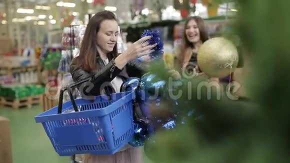 一群朋友在新年超市里玩得很开心他们为圣诞树挑选圣诞装饰品巨大的视频的预览图