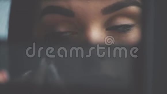 特写一个年轻女人的脸化妆一个漂亮的女人在眉毛上涂上眼影就是刷子视频的预览图