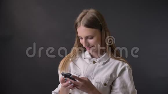 年轻酷女孩在智能手机上看照片她很感动沟通观念灰色背景视频的预览图