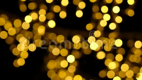 抽象模糊的金色闪光灯泡灯在黑色背景上视频的预览图