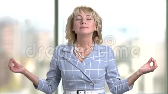 成熟的商业女性在办公室里冥想室内视频的预览图