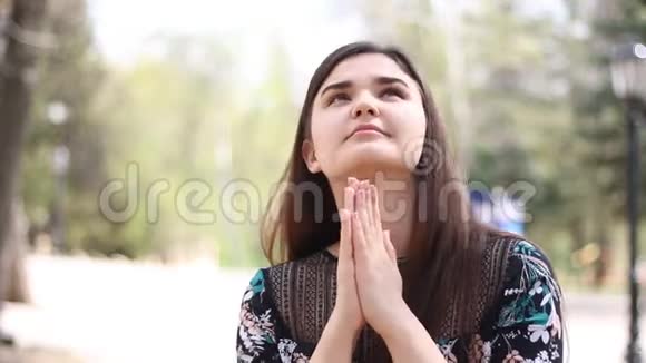 公园里的一个年轻女子虔诚地祈祷视频的预览图