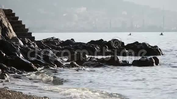 波浪在岩石上跳动两个驼峰漂浮在后方视频的预览图