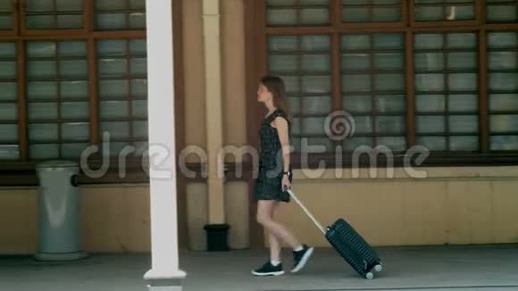 带手提箱的女孩在假日旅行时抵达老电影火车站视频的预览图