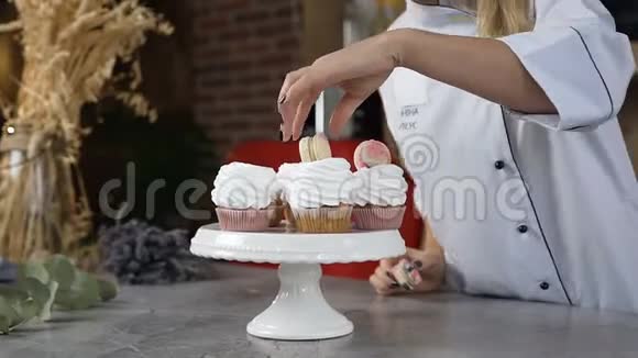 年轻厨师用马卡龙装饰蛋糕视频的预览图