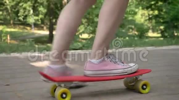 公园里的女足骑在滑板上亚洲女臀骑在滑板上背着背包视频的预览图