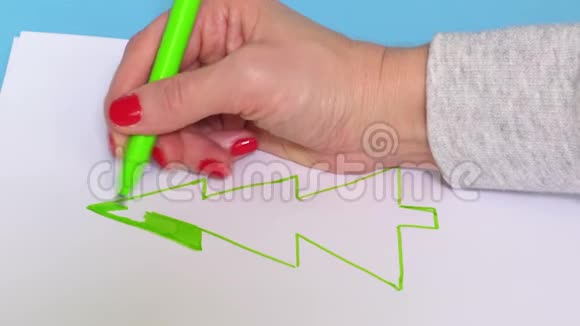 女人在白纸上画绿色云杉图案视频的预览图