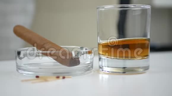 图片与雪茄烟灰缸玻璃与威士忌和火柴在桌子上视频的预览图
