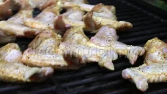 慢动作手把生块腌鸡放在烧烤架上视频的预览图