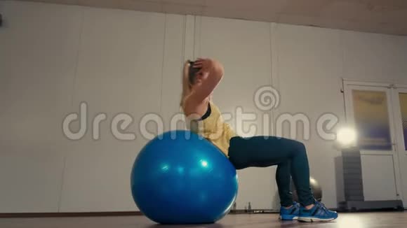 运动女士在健身房训练时正在进行健身球的仰卧起坐练习视频的预览图