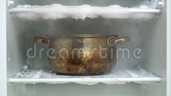 用盛满热水的厨房大锅解冻冰箱视频的预览图