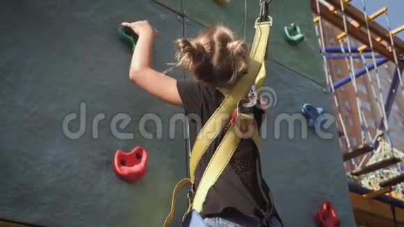 活跃的年轻女孩在冒险公园训练攀岩儿童通过障碍课程的困难部分积极主动视频的预览图