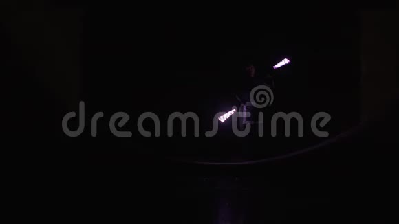 穿着黑色服装的马戏团艺术家在晚上用铅球表演魔术视频的预览图