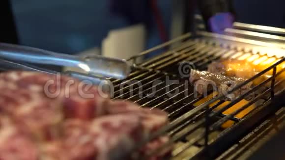 4k小贩在夜市的烤架上用喷灯烹制牛肉肉片视频的预览图