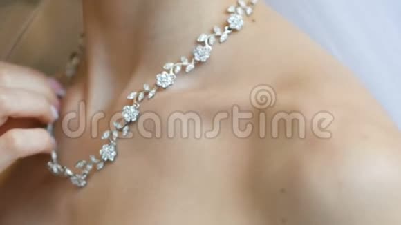 那女孩用精致的手拿着项链项链在脖子上新娘结婚的早晨广告珠宝视频的预览图