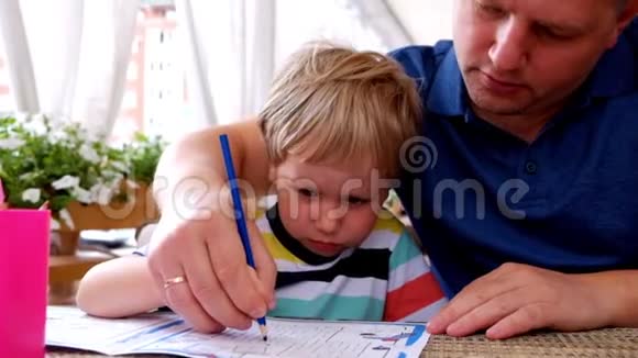 专心致志的男孩和他父亲在咖啡馆里画画视频的预览图