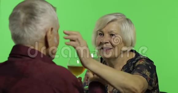 老年妇女与老年男子在Chroma键上的伴侣一起喝酒视频的预览图