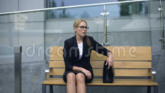 沮丧的办公室员工坐在长凳上紧张的会议后感到疲倦视频的预览图