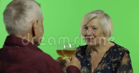 老年妇女与老年男子在Chroma键上的伴侣一起喝酒视频的预览图
