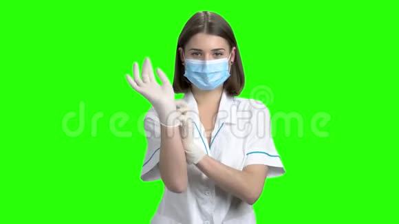 年轻女医生戴上手套的肖像视频的预览图