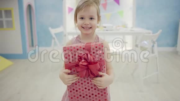 小女孩站在摄像机前拿着礼品盒视频的预览图