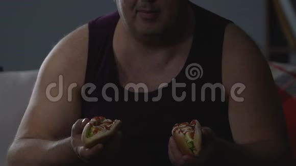 饥饿的男性吃两只热狗不健康的食物成瘾心理问题视频的预览图