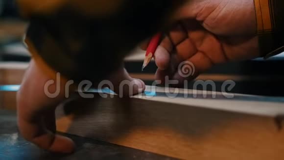 木工行业一名木工用铅笔和尺子在木制细节上做记号视频的预览图
