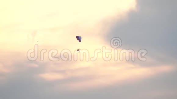 不知名的动力滑翔伞在日落的天空中飞得很高视频的预览图