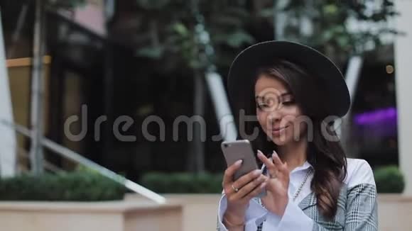 专业的年轻女商人用智能手机在城市街道上行走概念新业务交流银行家视频的预览图